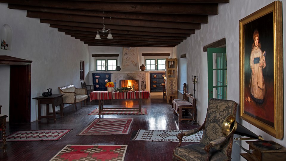The interior of the Hacienda at Los Luceros showing historic furniture and furnishings.