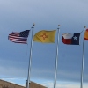 The flags of the United States, New Mexico, Texas, Spain and Mexico wave in the wind.