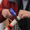 Hot-gluing items to a walking stick at the Yucca Walking Stick Workshop.